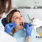 Kobieta w ciąży z bólem zęba u dentysty. Specjalista bada jej jamę ustną.