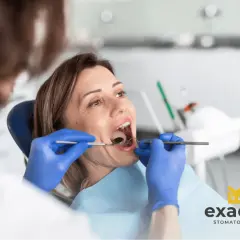 Kobieta w ciąży z bólem zęba u dentysty. Specjalista bada jej jamę ustną.