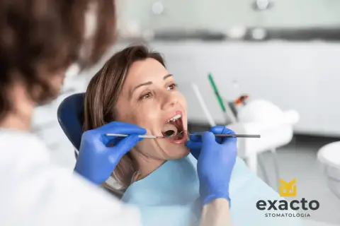 Kobieta w ciąży z bólem zęba u dentysty. Specjalista bada jej jamę ustną.