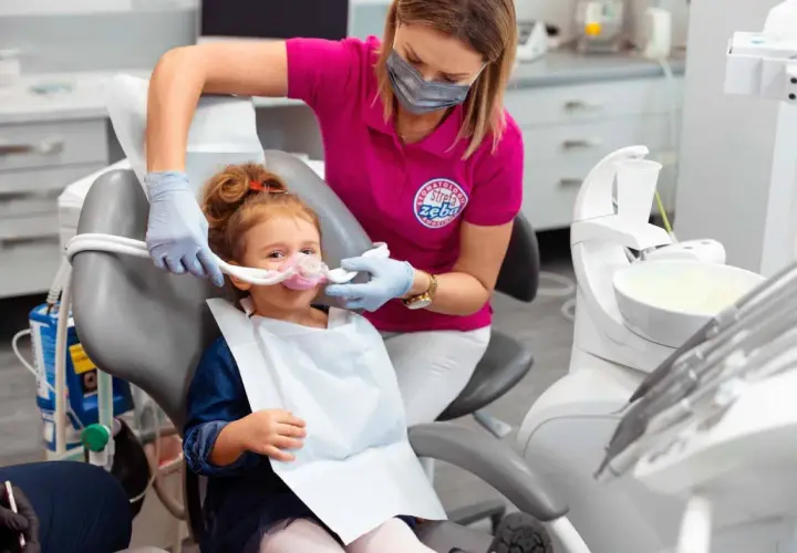 Dziecko w masce z podtlenkiem azotu u dentysty. Choć metoda ta minimalizuje stres, warto znać potencjalne podtlenek azotu skutki uboczne.