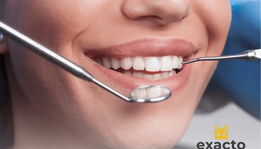 Uśmiechnięta pacjentka podczas wizyty w Exacto Stomatologia. Dentysta bada jej zdrowe zęby.