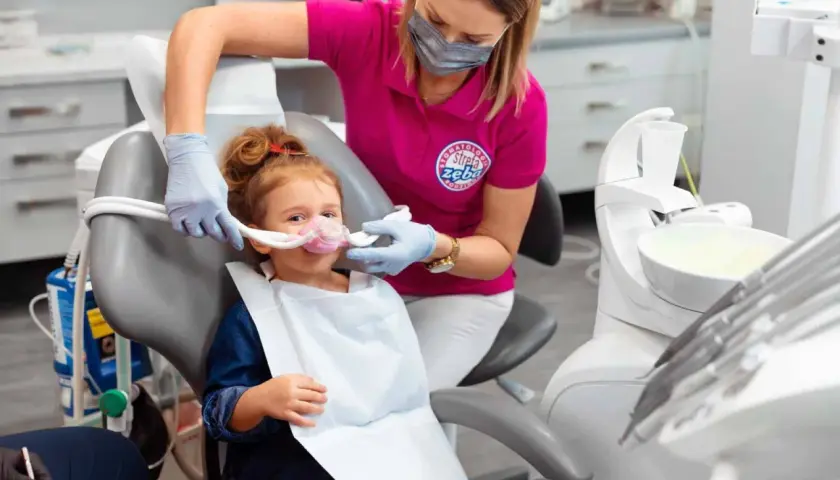 Dziecko w masce z podtlenkiem azotu u dentysty. Choć metoda ta minimalizuje stres, warto znać potencjalne podtlenek azotu skutki uboczne.
