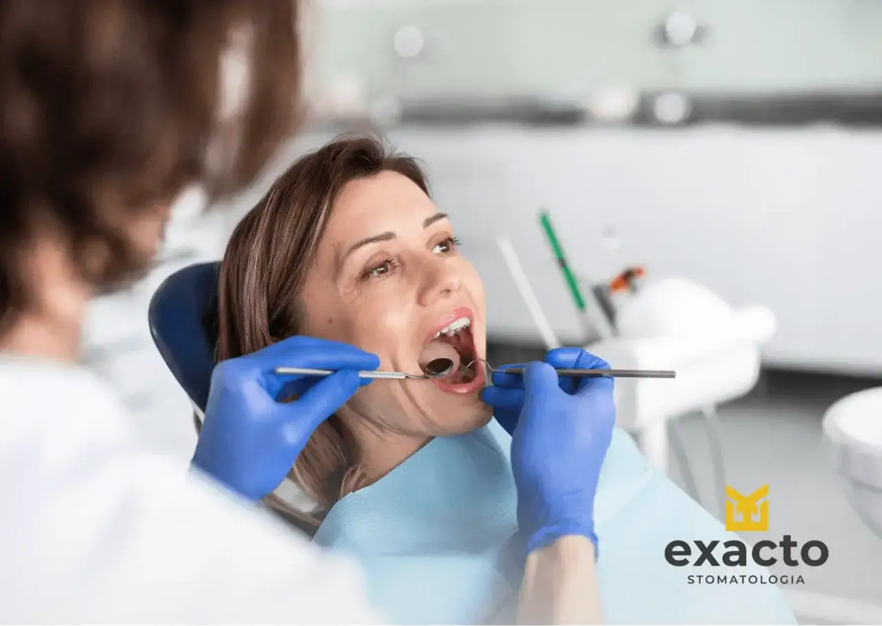 Kobieta w ciąży z bólem zęba u dentysty. Stomatolog bada jej jamę ustną.